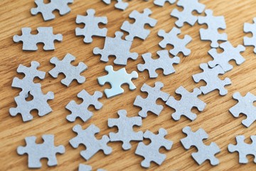 Jigsaw puzzle pieces scatteres around on the floor