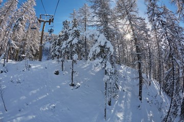 Skiing lift ascend in the Alps with snowy trees in Les Arres, France