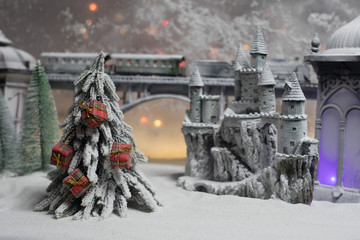 Miniature of winter scene with Christmas houses, train station, trees, covered in snow. Nights scene. New year or Christmas concept. Selective focus