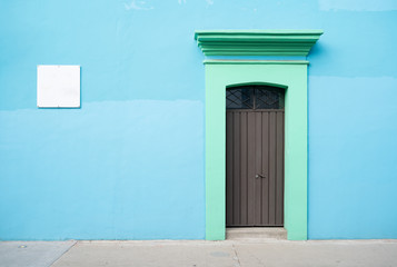 facade of blue old house and brown door