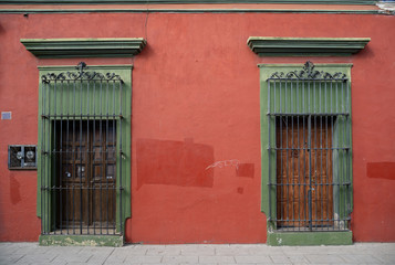 red and green facade of old house with two wooden doors