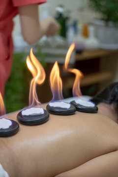 spa concept of orchid flower, zen basalt stones with drops, lilac candles, beads