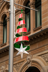 Sydney Australia, xmas decorations hanging from light poles in Martin Place with sandstone building in background
