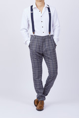 Hombre joven con tiradores y camisa en fondo blanco