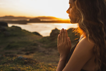 Woman praying alone at sunrise. Nature background. Spiritual and emotional concept. Sensitivity to nature - 308367401