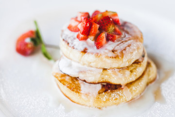 Strawberry pancakes with sour cream isolated on white background close-up. Traditional sweet and unhealthy american food with a lot of sugar.