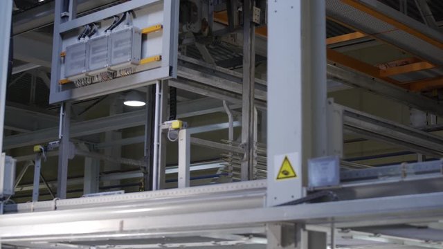 Aluminum profiles are immersed in a special solution with help girder crane. The process of anodizing of aluminum in the enterprise. Metal processing.