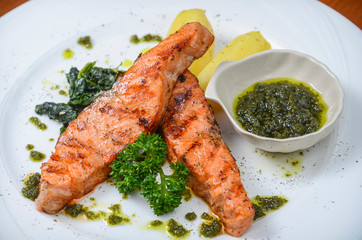 Grilled salmon and vegetables on the white plate.