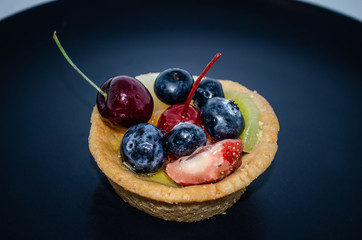 Fruit tart on black plate