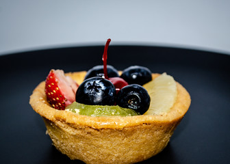Fruit tart on black plate