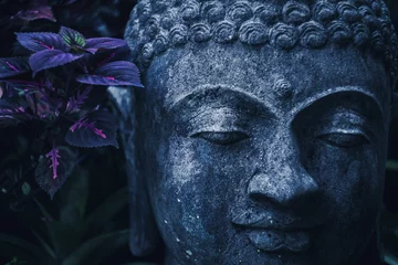 Fototapete Zen Stone Buddha Gesicht Nahaufnahme in trendigen blauen Farbtönen. Handgefertigte geschnitzte Buddha-Statue im balinesischen Garten als Dekoration.