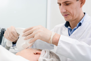 Male cosmetologist doing photo rejuvenation procedure for female client