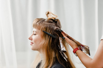 Closeup of professional stylist using brush to apply dye on clients hair