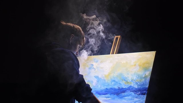 Artist copyist paint seascape with ship in ocean. Vaper smoke vape e-cigarette. Craftsman decorator draw as boat sail on blue sea with acrylic oil color. Draw finger, brush, knife palette. Indoor.