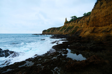 Waves on the seaside are splashing on the rocks in a stormy day