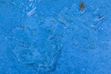 Clear ice imprints of frozen leaves on a textured surface in the winter