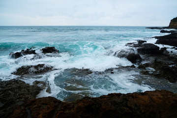 Waves on the seaside are splashing on the rocks in a stormy day