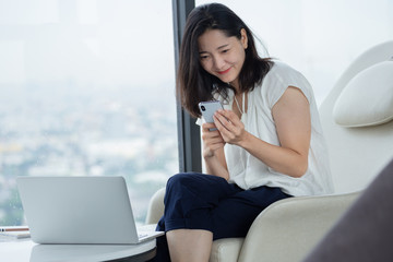 hand holding using texting cell phone and typing computer.business woman at workplace Thinking investment plan.chat contact Investor.searching for information use internet.connecting people concept