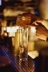 Fototapeta na wymiar Bartender prepairing a cocktail at the bar. Lifestyle image, selective focus