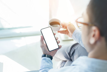 Mockup image blank white screen cell phone.men hand holding texting using mobile on desk at home office. background empty space for advertise text.people contact marketing business and technology 