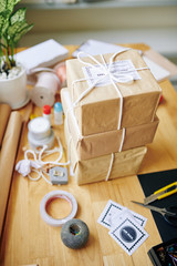 Stack of wrapped parcels on table in home office of person selling handmade goods