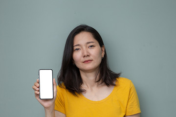 Naklejka premium Mockup image blank white screen cell phone.woman holding texting using mobile on background space for text.background empty space for advertise text.people contact marketing business and technology 
