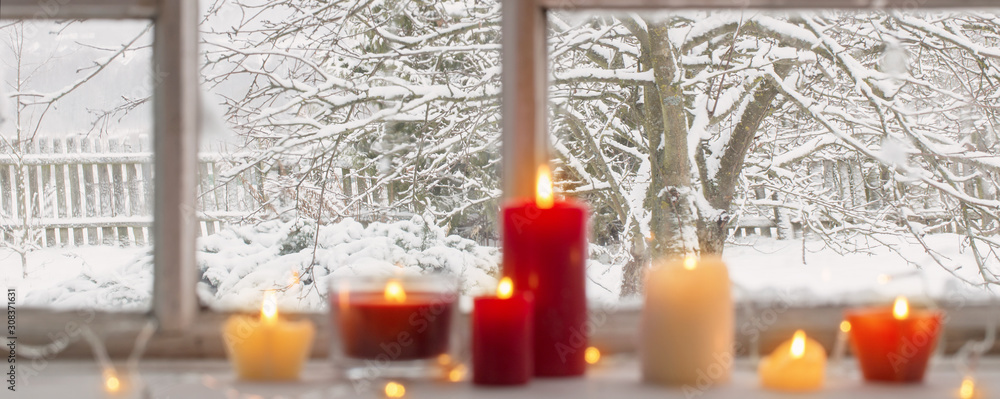 Wall mural burning candles on a windowsill