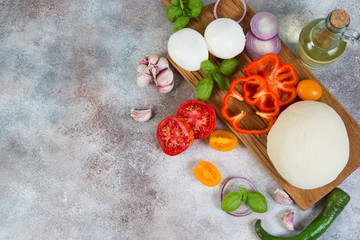 Fresh pizza products lie on a concrete background. Horizontal photo with copy space.