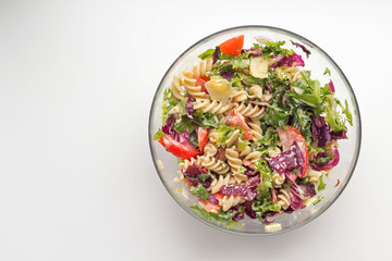 Vegetable salad with pasta and cheese on white background. Vegetarian, recipe, culinary, cooking concept. Top view, close-up, copy space