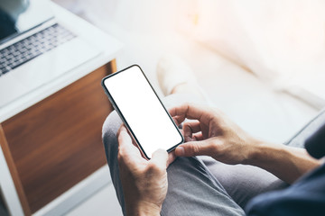Mockup image blank white screen cell phone.men hand holding texting using mobile on desk at home office. background empty space for advertise text.people contact marketing business and technology 