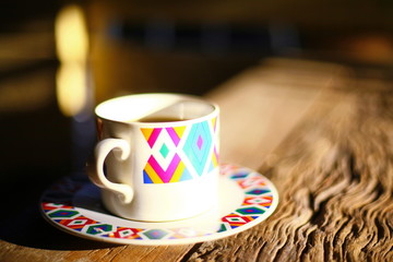 Hot coffee and morning sunshine on a wooden table