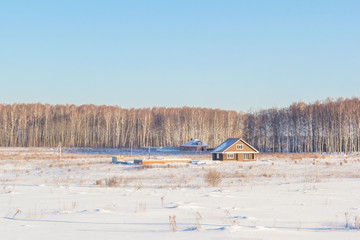 Houses in a snowy field on a sunny day
