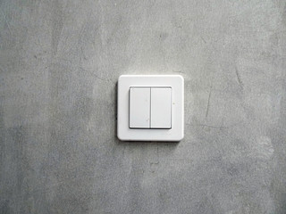 Rectangular-shaped lamp switch on cement-finished wall