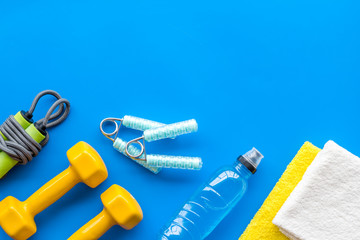 Sport equipment for self-development. Composition with dumbbells on blue background top-down frame copy space