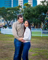 Fototapeta premium Happy young couple posing in front of the Christmas tree in a city park, Florida
