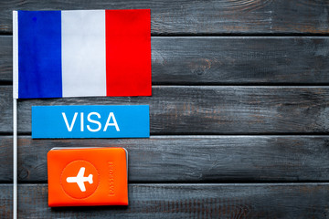 Visa to France concept. French flag near passport on dark wooden background top-down copy space