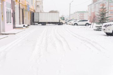 Fototapeta premium Snowfall in the city cars in the snow on the street