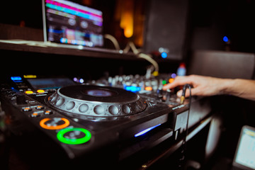 Obraz premium Dj mixing outdoor at beach party festival with crowd of people in background - Summer nightlife view of disco club outside - Soft focus on hand - Fun ,youth,entertainment and fest concept