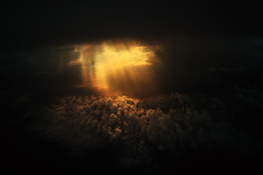 Dramatic god light rays shining from dark cloud on to clouds expanse on the sky. power of hope and god induce strength. light through darkness.