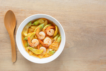 hot and sour katuri flower soup with shrimp in a bowl on wooden table, top view. asian homemade style food concept.
