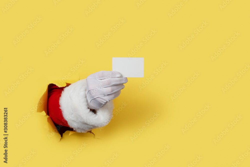 Wall mural Santa Claus Holding a Blank White Card isolated over yellow