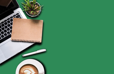 Office supplies are tablet, pen, computer, notebook, mobile phone and red coffee mug placed at an office desk and have a Sea green background.