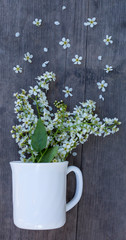 a bouquet of white flowers in a Cup on a wooden background, the concept of a morning Breakfast with a fragrant hot drink in a rustic