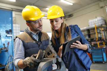 Mechanical workshop manager giving instructions to employee