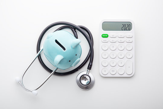 Piggy bank with stethoscope with calculator, top view