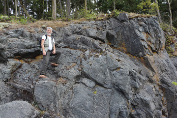 Man with a backpack climbing a rock, Deception  Pass State  Park, Washington State, USA