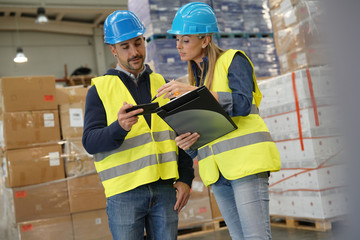 Workers in warehouse controlling incoming merchandise