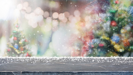 Empty mable stone table top on blur with bokeh Christmas tree and new's year decoration on window...