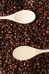 Obraz premium Empty wooden spoon on a coffee beans background. Close up. Dark concrete. Top view. Empty space.