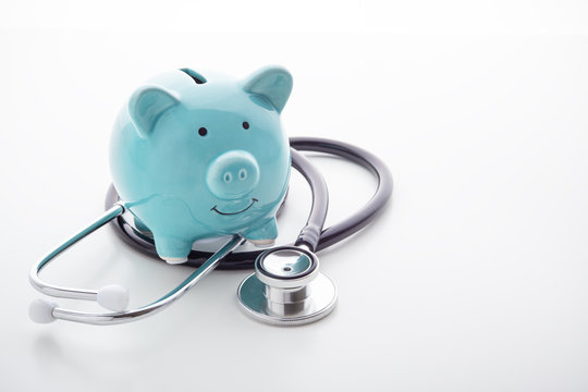 Piggy Bank With Stethoscope On White Background